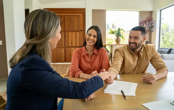 a woman shaking hands with a man at a table