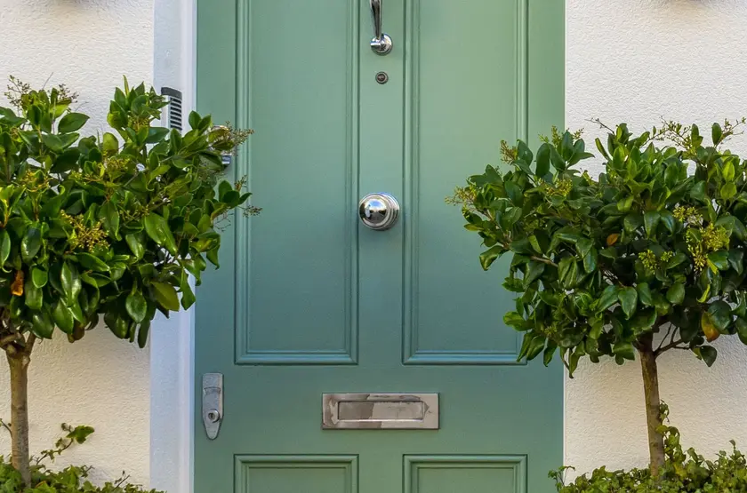 a green door with a handle and a doorknob