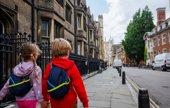 a boy and girl walking down a sidewalk